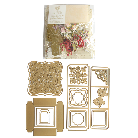 Explosion House Dies and Materials—gold-colored metal dies with ornate shapes, frames, a bow, and elegant embellishments in decorative floral packaging—perfect for adding detail to exploding box cards.