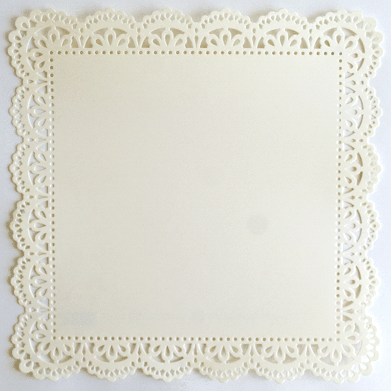 A white paper doily on a white surface.