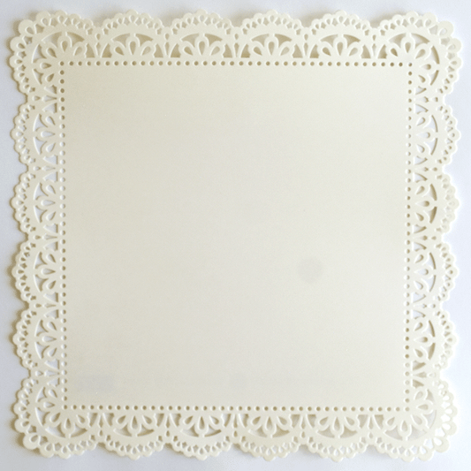 A white paper doily on a white surface.
