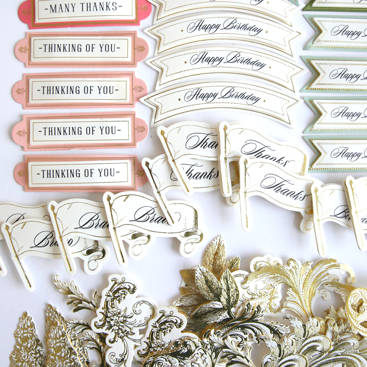 A collection of Garden Fountain Embellishments Craft Box cards and tags on a white surface, adorned with embellishments and displayed using easel cards.