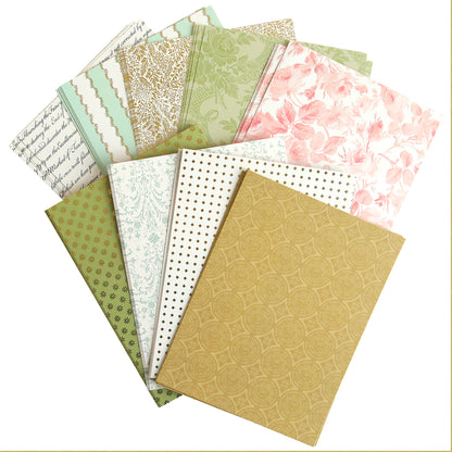 A stack of Garden Fountain Double Sided Cardstock layers with different designs on them, perfect for paper crafting projects.
