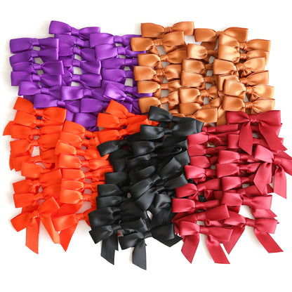 A collection of small satin bows in purple, gold, orange, black, and red—arranged in tidy rows and perfect for adding a festive touch to your Haunted Halloween Haul or embellishing your favorite Halloween stickers.