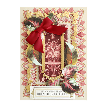 Haunted Halloween Haul greeting card featuring gold embellishments, spooky-themed designs, a red ribbon bow, and a label that reads “Joy & happiness are born of gratitude.” Crafted from premium glitter cardstock, this card makes a sparkling addition to your collection.