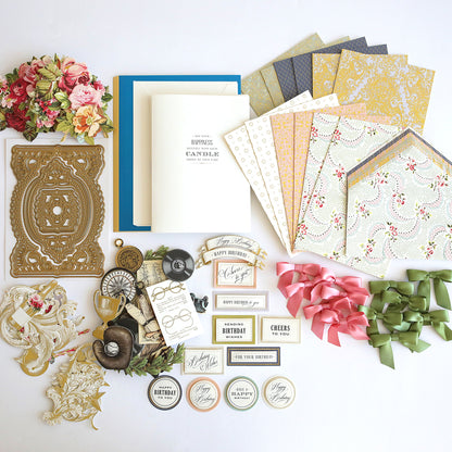 A variety of Beautiful Birthday Class Materials and Dies by Anna Griffin are laid out on a table.