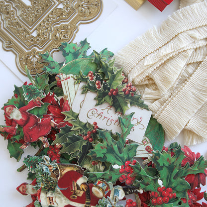 A collection of holly leaves, ribbons, and other decorations on a table, complemented by Anna Griffin's Victorian Christmas Class Materials and Dies.