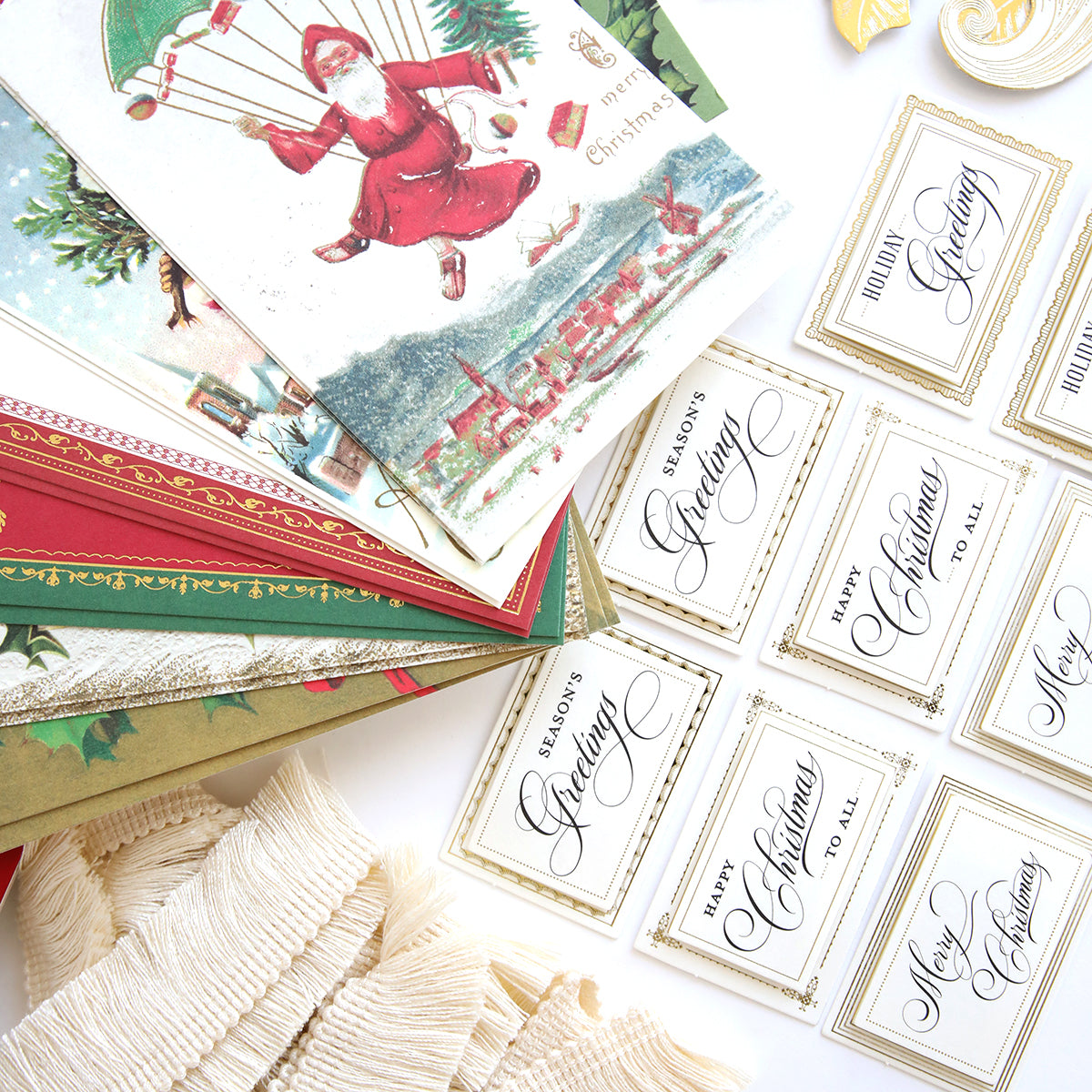 A festive arrangement of Christmas cards and ribbons, adorned with colorful supplies like Anna Griffin Victorian Christmas Class Materials and Dies, elegantly displayed on a table.