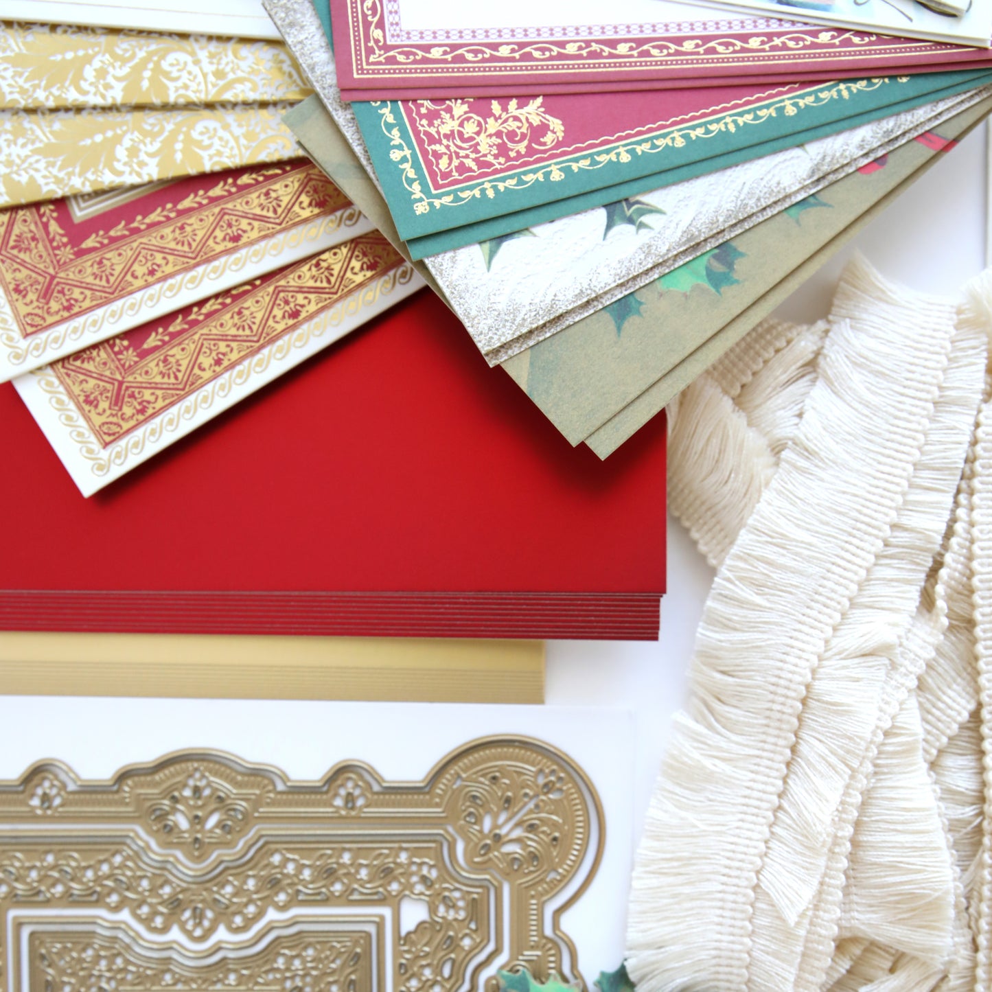 A variety of Anna Griffin Victorian Christmas Class Materials and Dies are laid out on a table, ready to be used for creating beautiful Christmas cards.