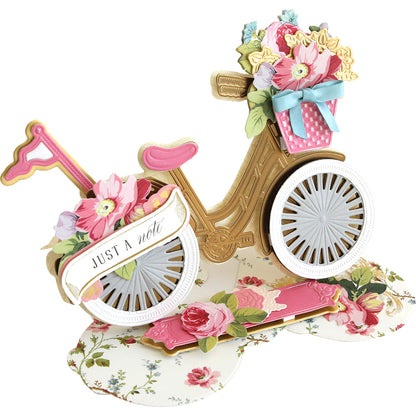 3D Bicycle Easel Die crafted of a vintage bicycle adorned with colorful embellishments and a tag reading "just a note.