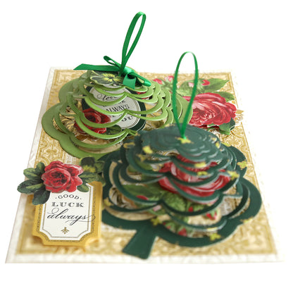 A Christmas card with a green tree and red roses, featuring the Shamrock Kirigami Dies.
