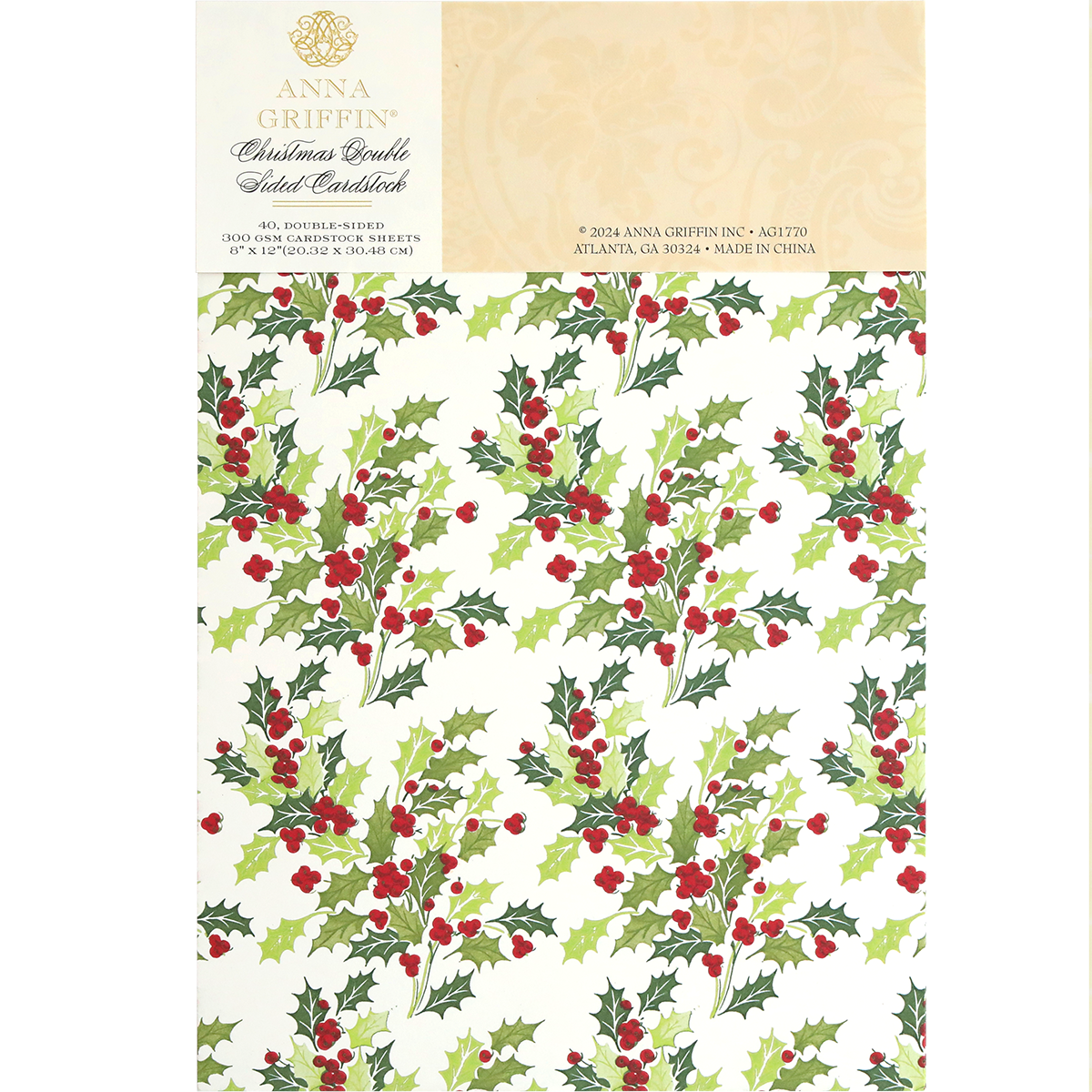 A sheet of Christmas Double Sided 300gsm Cardstock featuring a festive design of green holly leaves and red berries. The packaging label includes the brand name and manufacturing details, perfect for AG Members who appreciate high-quality, double-sided papers.