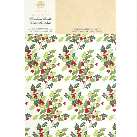 A sheet of Christmas Double Sided 300gsm Cardstock featuring a festive design of green holly leaves and red berries. The packaging label includes the brand name and manufacturing details, perfect for AG Members who appreciate high-quality, double-sided papers.