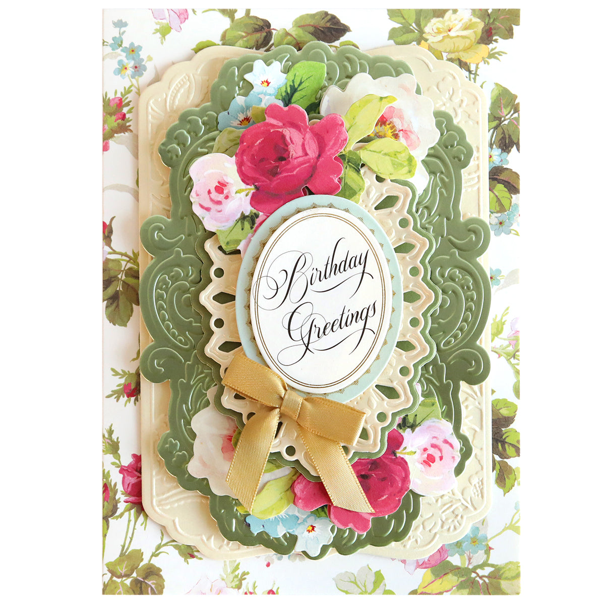 A decorative birthday card with floral patterns and a central "birthday greetings" message, adorned with a golden ribbon and enhanced by Card Layer Cut & Emboss Folders for creating dimension.