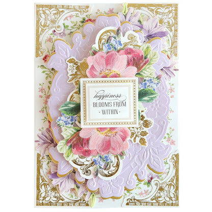 Greeting card featuring elaborate floral design with a central pink bloom and the message "happiness blooms from within" framed by pastel flowers and gold accents, enhanced by creating dimension using Card Layer Cut & Emboss Folder.