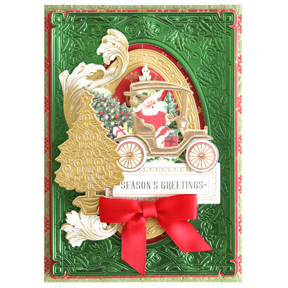 A festive handmade Christmas card featuring a raised design of Santa in a vintage car with a Christmas tree, ornate gold detailing, a red ribbon, and the message "Season's Greetings," crafted using Christmas Greetings 3D Concentric Dies for an enchanting effect.