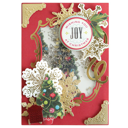 A festive Christmas card featuring gold embellishments, a decorated tree, snowflakes, and a "Wishing You Joy at Christmas" message. This delightful creation can be brought to life using the Shaker Card Supply Kit for added sparkle and fun.