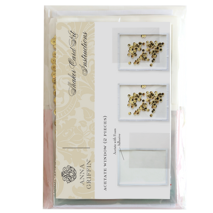 Image of the Shaker Card Supply Kit by Anna Griffin, featuring acetate windows and gold embellishments. The kit includes instructions, sequins, and materials for creating stunning shaker cards, all displayed in clear packaging.