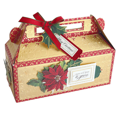 A decorative gold and red box with a poinsettia design, featuring a ribbon, gift tag reading "Merry Christmas," and a handle for carrying.