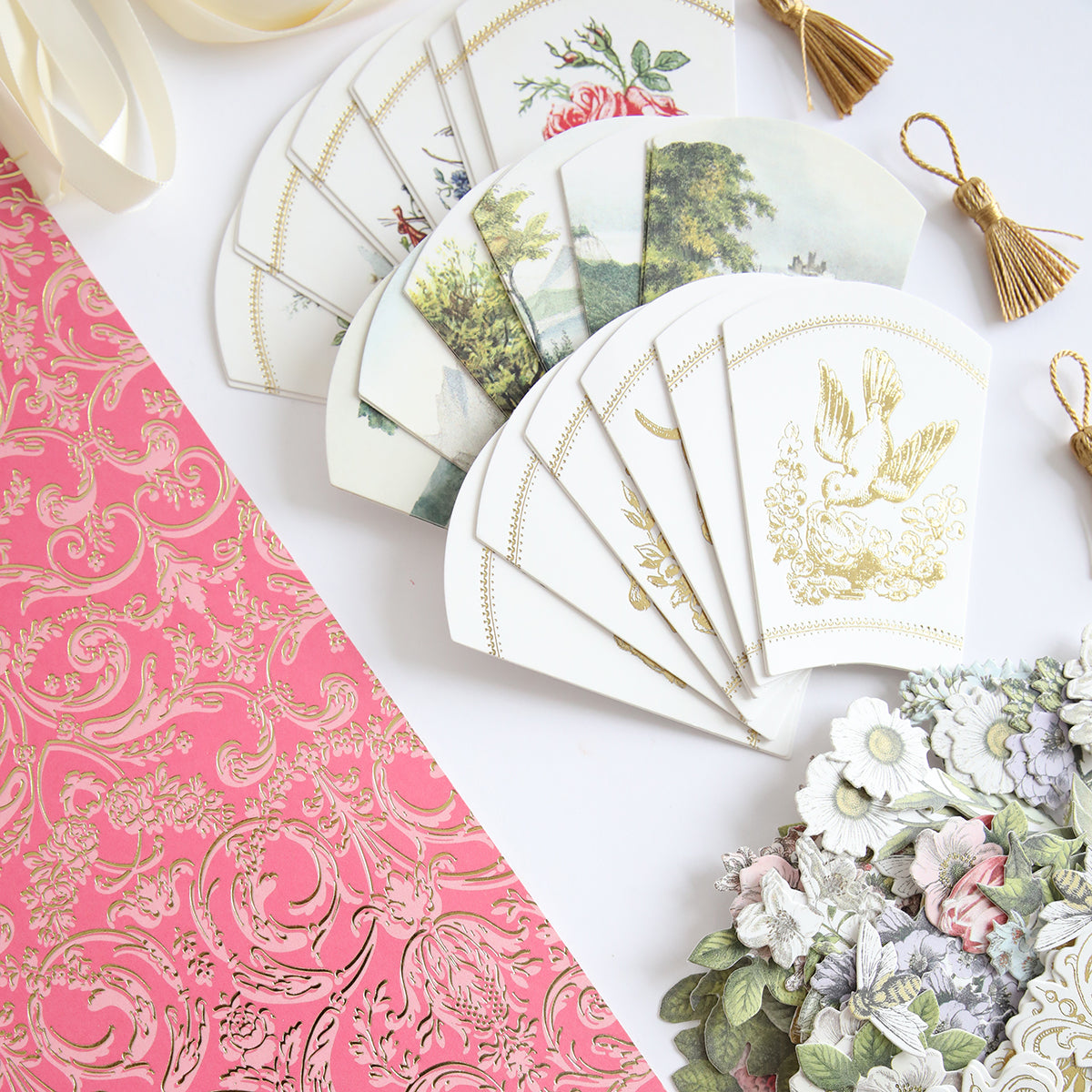 The French Fans Refill Kit includes a selection of vintage-style paper crafts, featuring a pink patterned sheet, illustrated envelopes, and floral die-cuts.