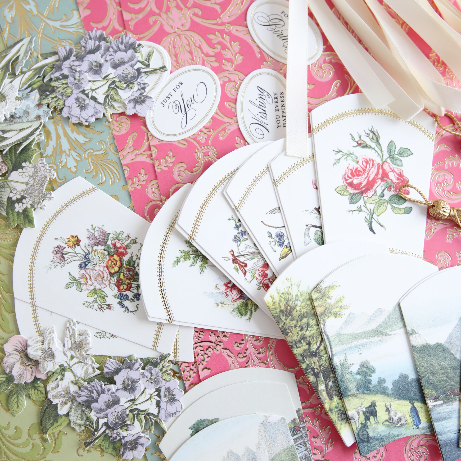 The French Fans Refill Kit, showcasing a mix of pastel and vibrant-colored decorative papers, patterned cards, and cutouts, is beautifully arranged on a table.