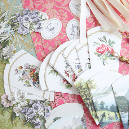 The French Fans Refill Kit, showcasing a mix of pastel and vibrant-colored decorative papers, patterned cards, and cutouts, is beautifully arranged on a table.