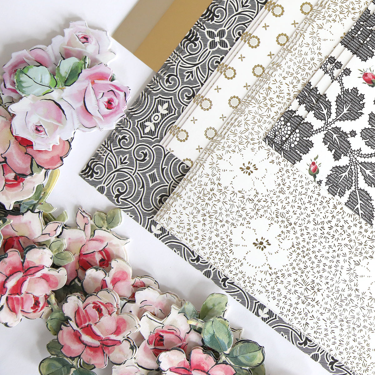 The Stylish Hats Refill Kit includes an assortment of decorative paper and floral stickers adorned with intricate black and white patterns alongside pink roses.