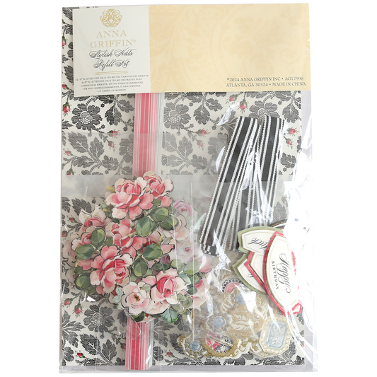 A decorative kit called the "Stylish Hats Refill Kit" includes floral-patterned paper, pink flowers, striped ribbon, and various tags in a clear package.