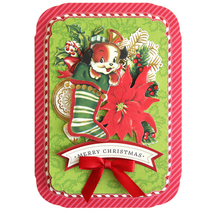 This Simply Retro Christmas Card Making Kit includes a vintage-style design featuring a playful puppy in a green stocking surrounded by vibrant red poinsettias and holly, complete with charming 3D embellishments and a "Merry Christmas" banner. The look is finished with a festive red and white striped border.