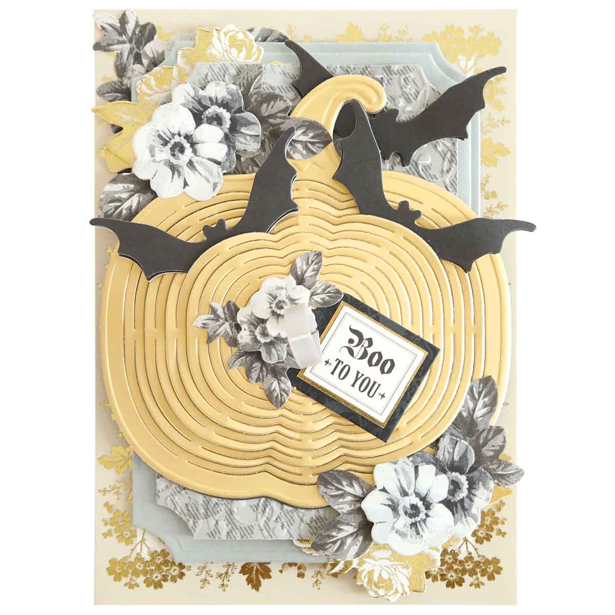 The Pumpkin Kirigami Dies greeting card features a yellow pumpkin, black bats, and white flowers set against a white and gold background. The intricately diecut layers of the pumpkin include a sign that reads "Boo to You.