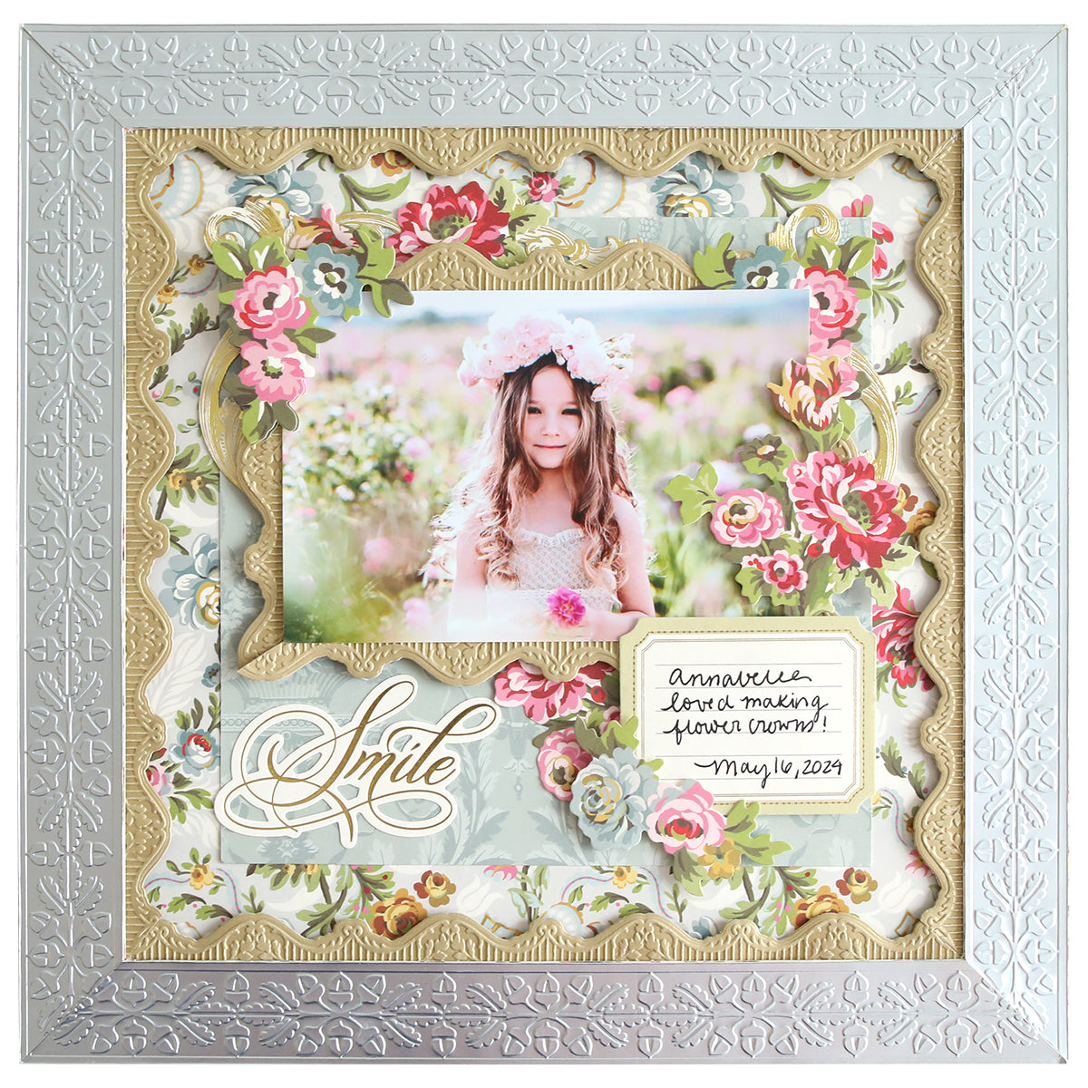 A beautifully adorned floral frame showcases a photo of a young girl wearing a flower crown, enhanced by elegant borders from the 12" Cut and Emboss Folder Autoship collection. A sentimental note reads "Annabelle, fond memories, Prince Edward Island, May 14, 2023," with "Smile" written in graceful cursive.