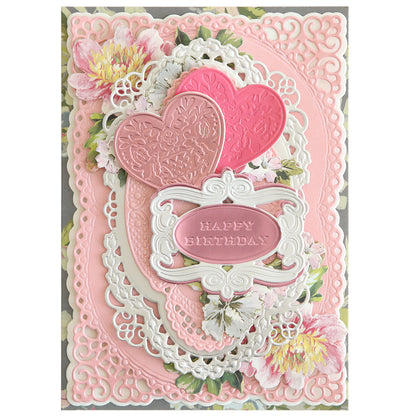 A decorative birthday card created using the Celebrations 3D Embellishment Dies, featuring intricate layers of pink and white lace patterns, floral designs, and two embossed hearts with the text "Happy Birthday" displayed in the center—a perfect way to celebrate life's special moments from birthdays to anniversaries.