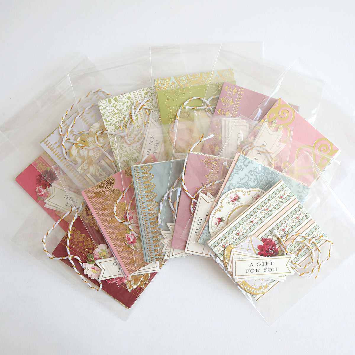 Creative Birthday Tags and Dies: decorative gift tags featuring vintage floral patterns, gold accents, and twine ties in plastic sleeves, with labels reading “A Gift For You” and “Just For You.”