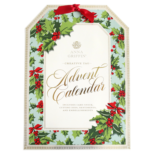 Advent calendar packaging decorated with green leaves, red berries, and red bows, labeled "Creative Tags Advent Calendar," and includes card stock, cutting dies, sentiments, and embellishments.