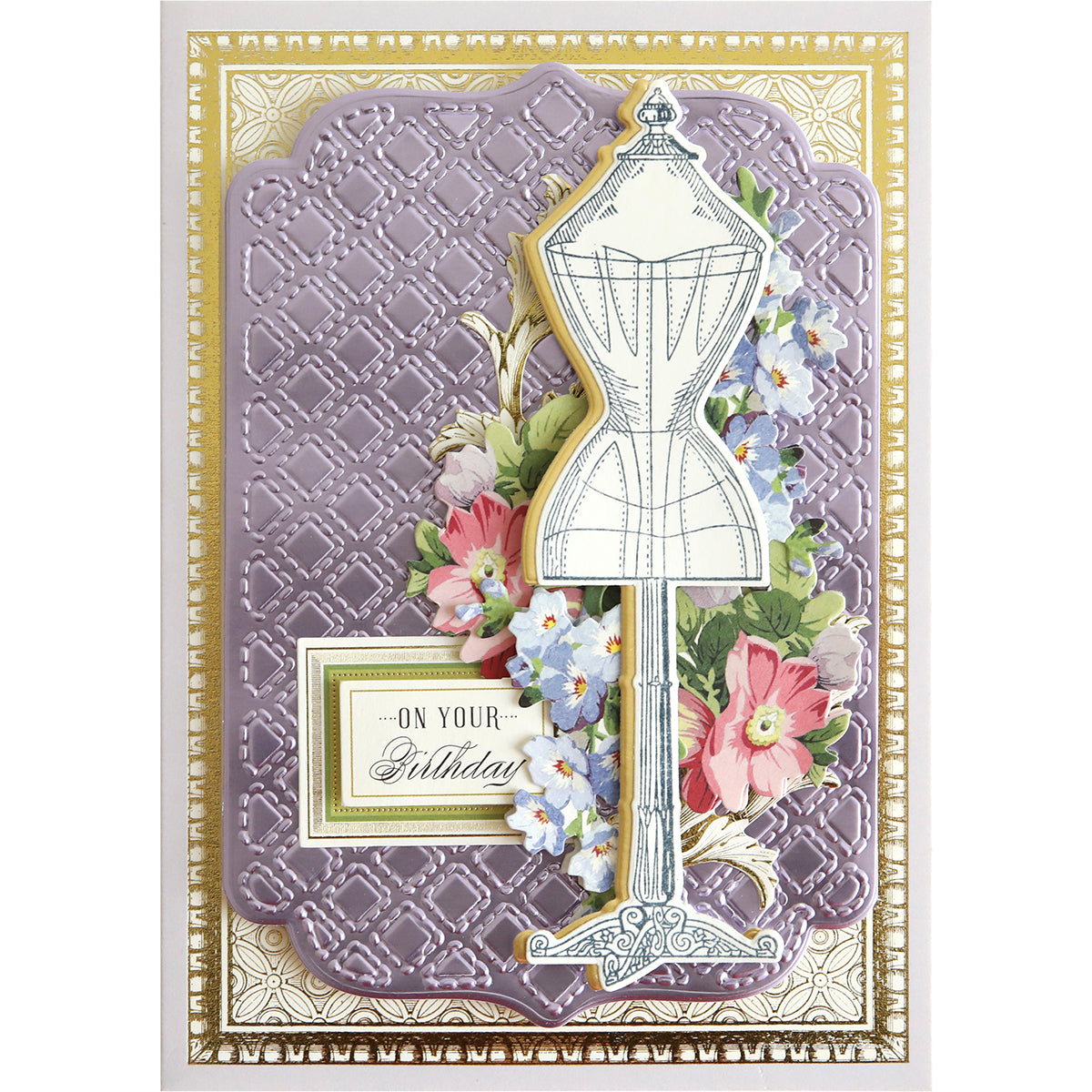 A beautiful greeting card, crafted with the "Quilted Layer Cut & Emboss Folders," showcases a vintage dress form surrounded by colorful flowers and ornate patterns. It features the text "On Your Birthday" and is framed with exquisite gold and purple embossed details that add depth and texture through its quilted layers.