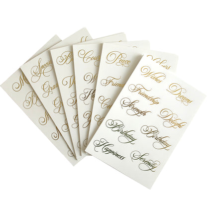 The Perfect Title Stickers, featuring several white cards with gold cursive text displaying positive words like "Peace," "Friendship," and "Serenity," are ready to adorn your scrapbook pages.