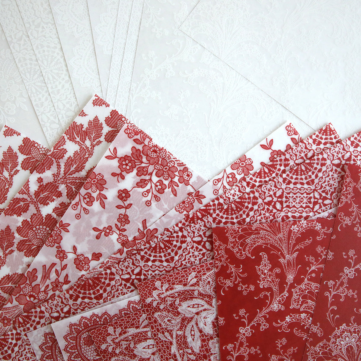 The Red and White Lace Vellum Papers, available in a set of 24 sheets, feature intricate floral and lace patterns on 12" x 12" printed vellum, arranged in overlapping layers for a transparent appearance.