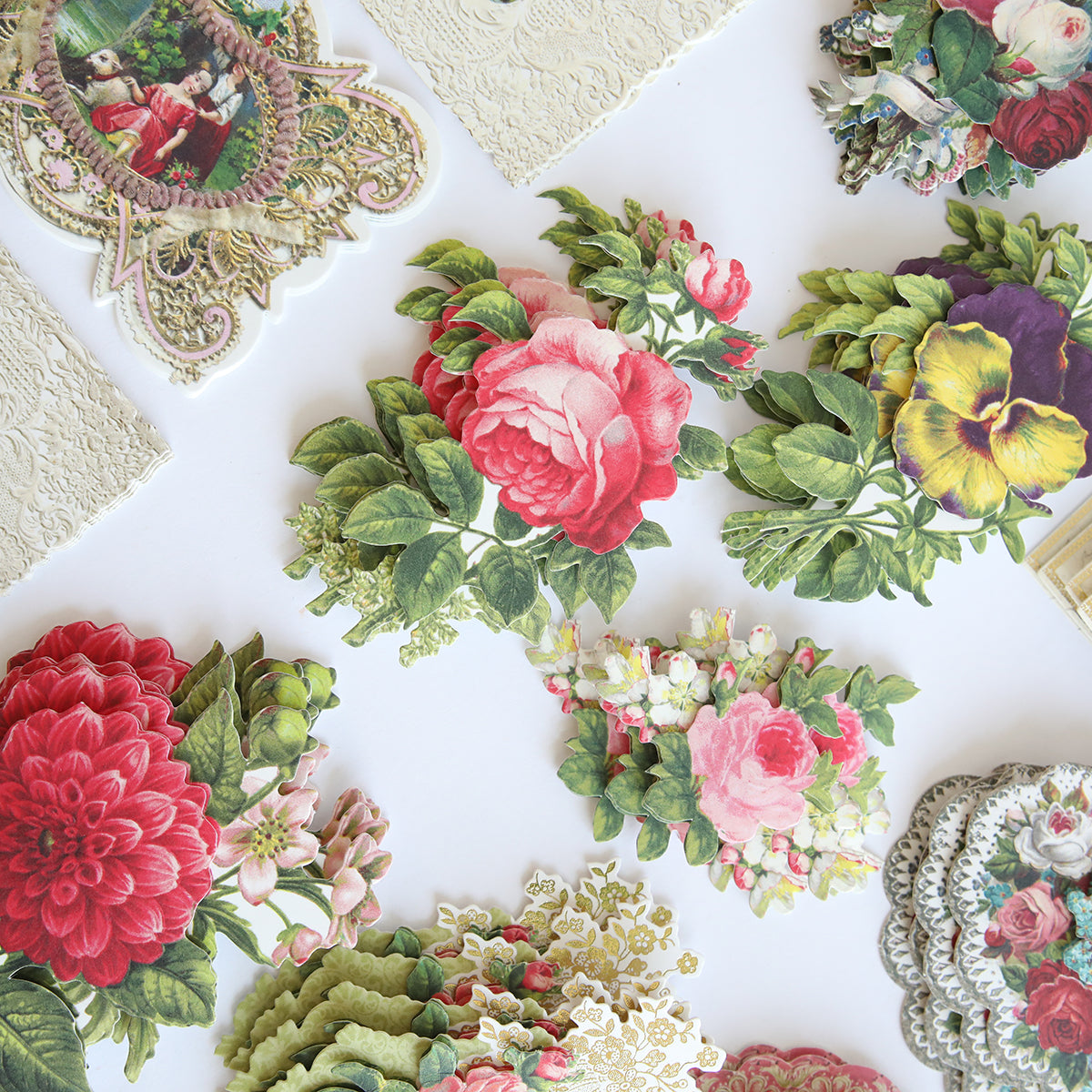 Introducing Love Ephemera Stickers: a collection of vintage-inspired floral die-cuts adorned with roses, pansies, and various other blossoms on a white background. These charming stickers are ideally complemented by delicate lace doilies for an extra hint of elegance.