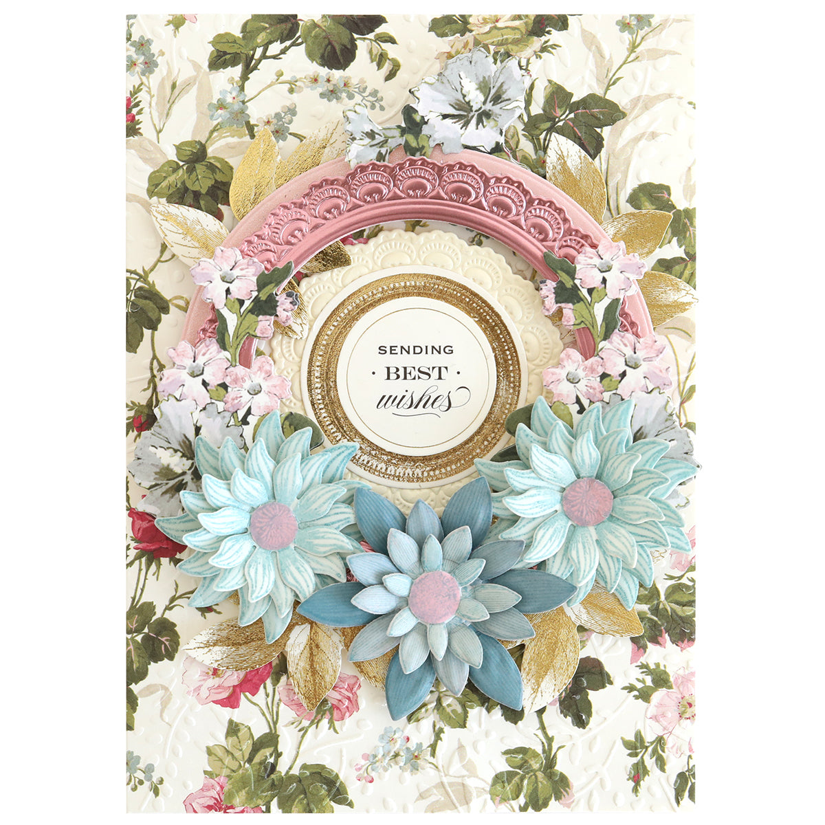 The Blooms Flower Mold, Stamps and Dies set creates a decorative greeting card with blue and white paper flowers, gold leaves, a "Sending Best Wishes" label in the center, and coordinating stamps that highlight the floral details.