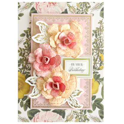A decorative birthday card made with the Posies Flower Mold, Stamps and Dies, featuring three large pink and yellow flowers, green leaves, and an "On Your Birthday" label on a floral background.