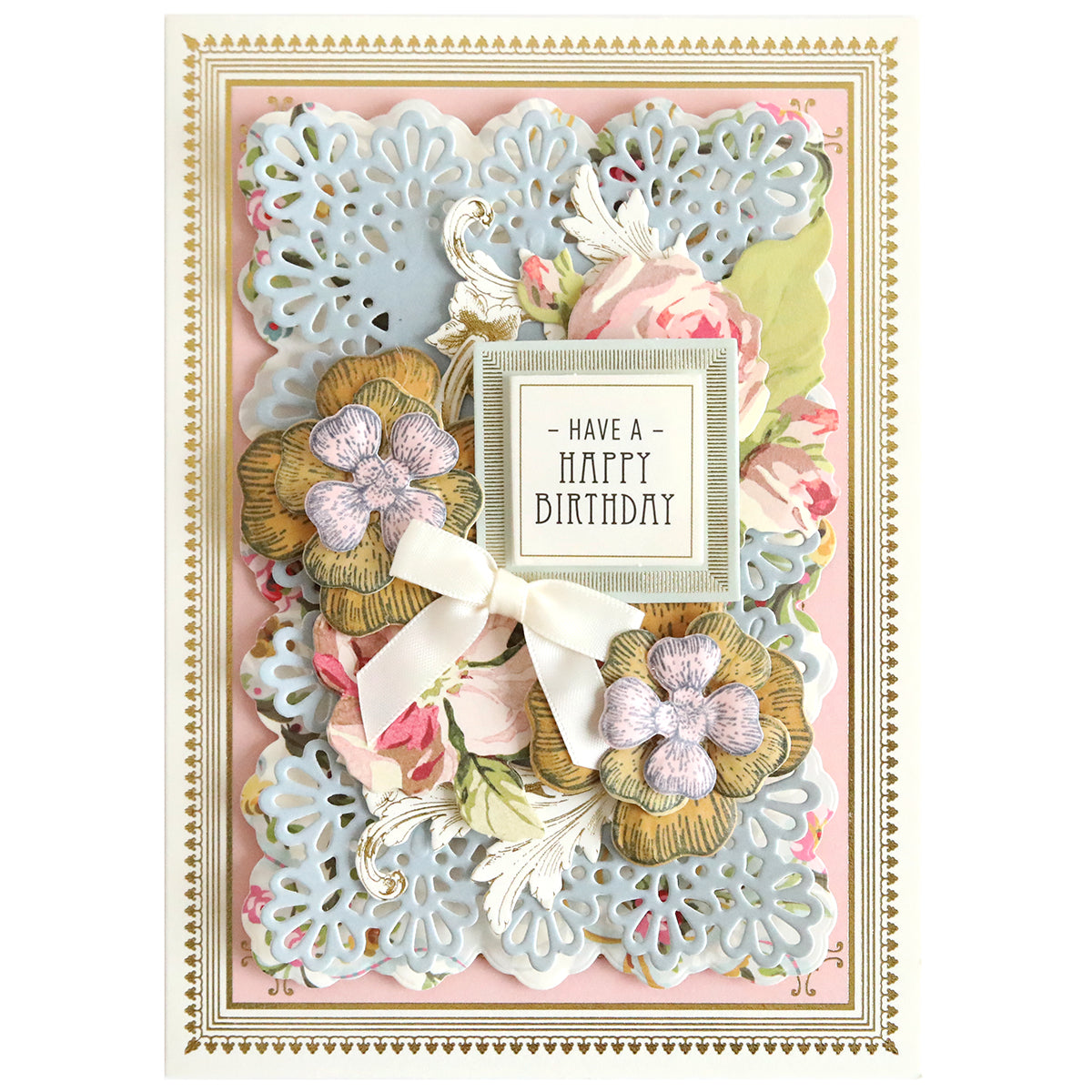 An ornate birthday card boasts paper flowers and lace-like patterns, adorned with a delicate ribbon. The central text reads "Have a Happy Birthday" in a decorative frame, enhanced by intricate floral designs using Blossoms Mold, Stamps and Dies for added dimension.