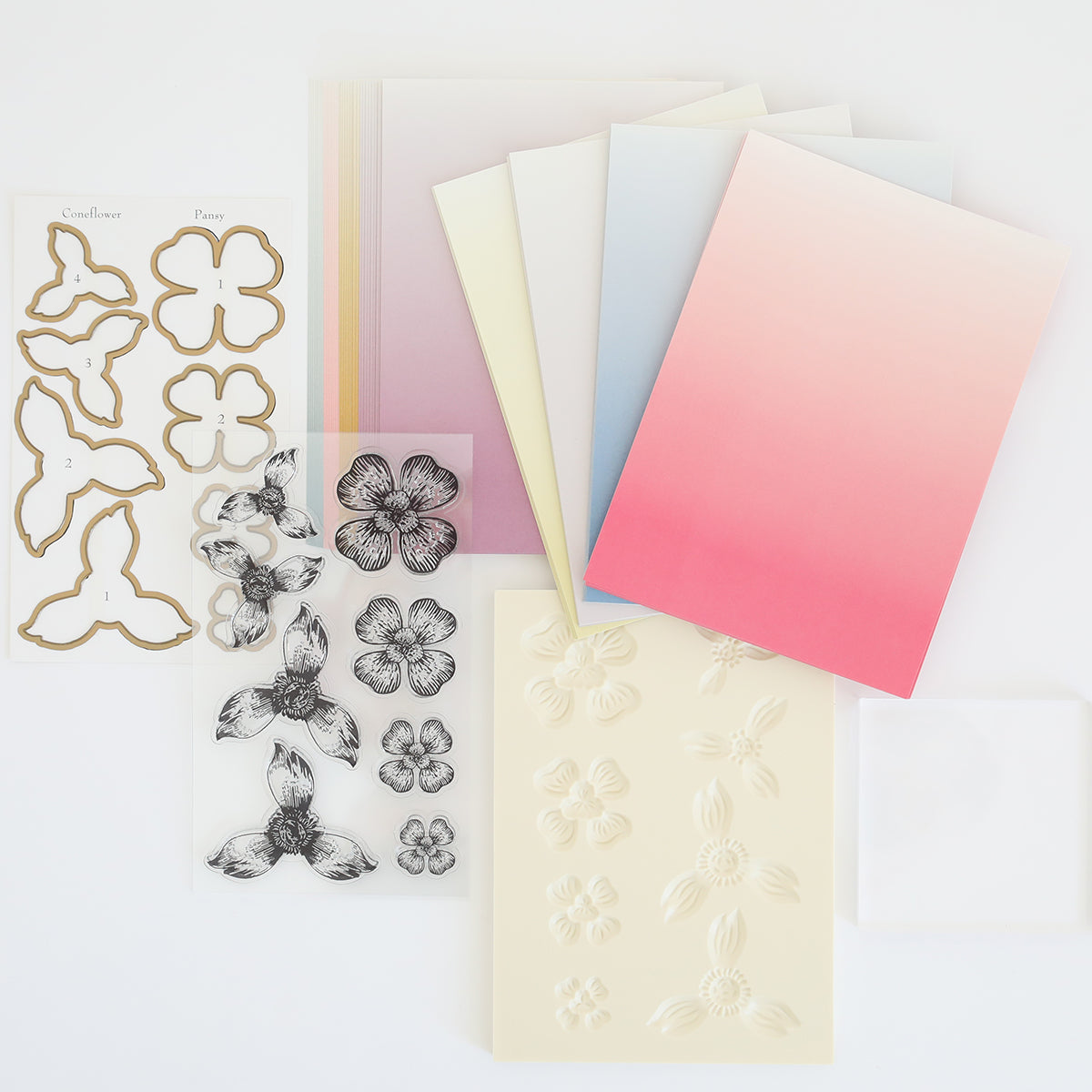 The Blossoms Mold, Stamps, and Dies collection offers floral-themed crafting supplies like colored and embossed paper, flower-shaped cutouts on white backgrounds, stamped designs, clear stamps for precision, and a flower shaping mold for crafting delicate paper florals.