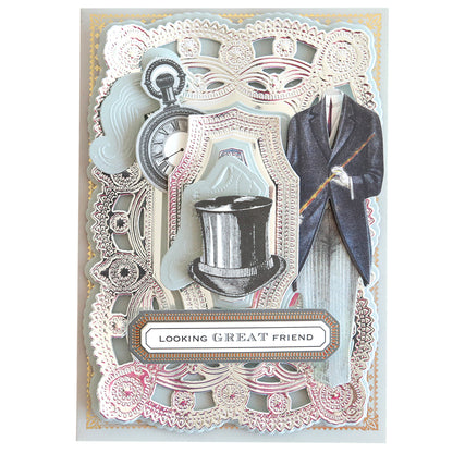 Vintage-style card with ornate lace patterns, featuring a die-cut top hat, pocket watch, and a headless figure in a suit on Luxury Mirror Foil Cardstock. Text reads "Looking Great Friend.