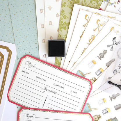 A selection of decorative products, including the Recipe Card Stamps, Dies and Embellishments set featuring cutting dies and kitchen utensil stationery, artfully arranged on a surface.