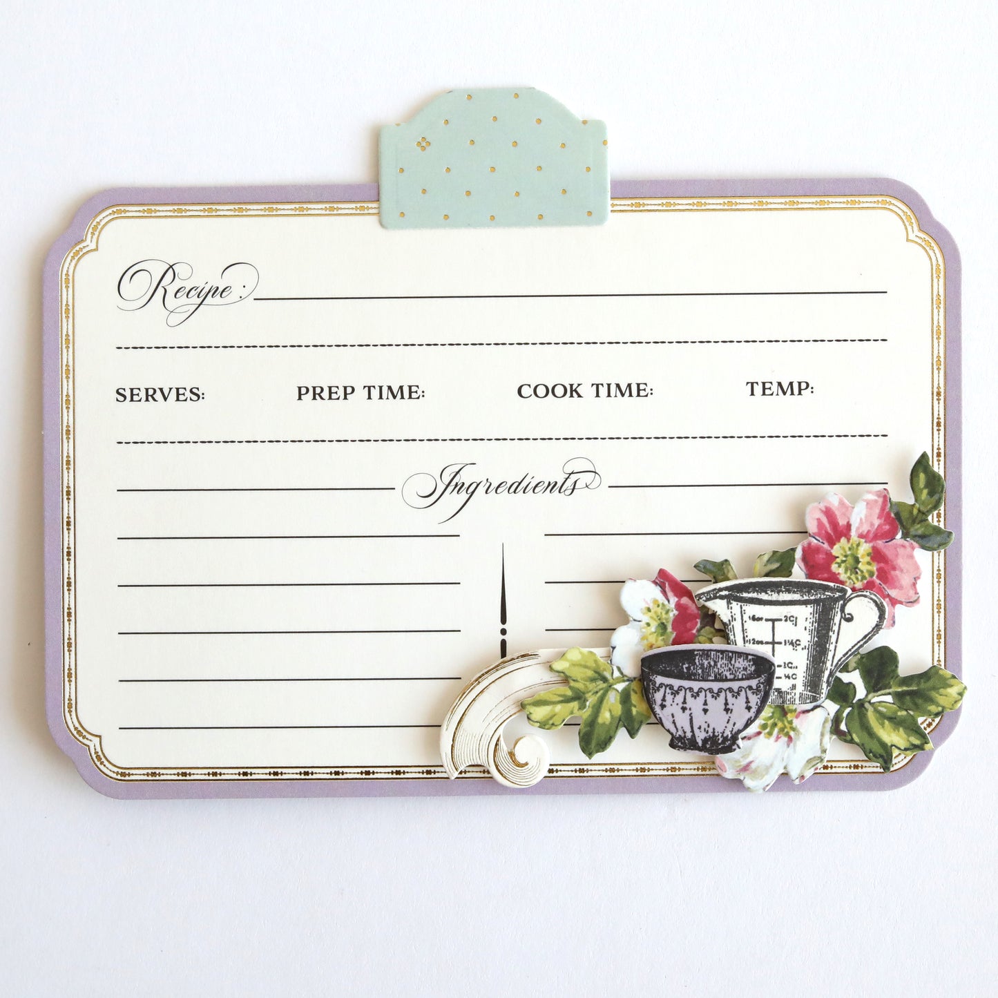 The Recipe Card Stamps, Dies and Embellishments set features recipe cards with sections for name, serves, prep/cook time, temp, and ingredients. Adorned with a measuring cup, flowers, and leaves, it complements your crafting collection when paired with cutting dies and clear stamps.