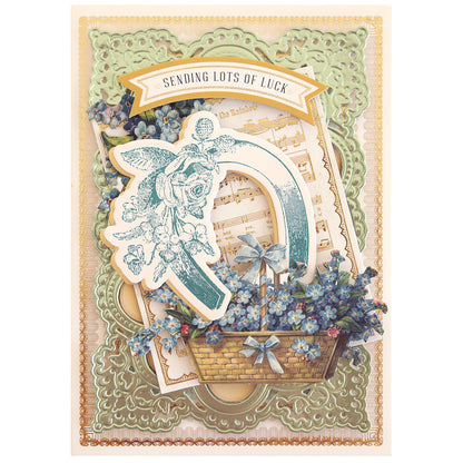 The Lucky Stamps Dies features a decorative card with a horseshoe and floral design, musical notes, and a banner reading "Sending Lots of Luck." It's perfect for adding charm to scrapbook pages.