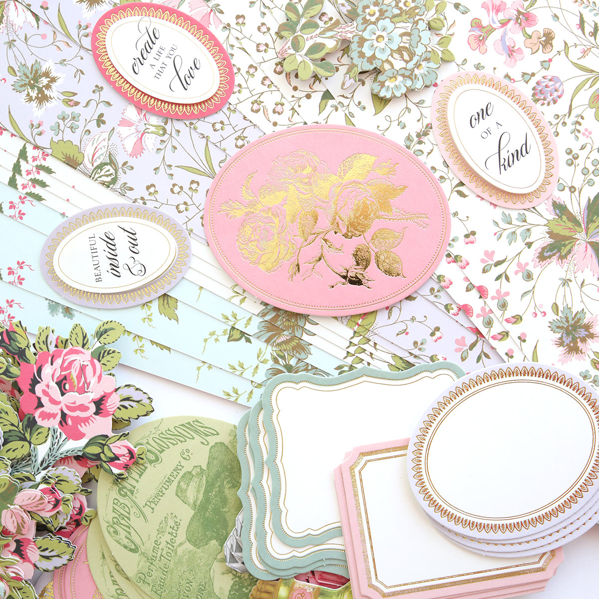 The Mirror Card Craft Box features a floral-themed stationery collection, complete with cards, ornate oval tags adorned with phrases, all set against a floral background enhanced by shimmering foil embellishment stickers.