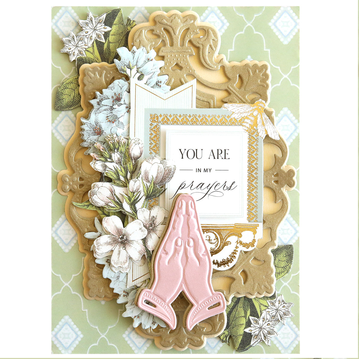 Decorative card featuring a Praying Hands Dies floral design with gold embellishments and pink stained-glass-like hands. The text "You are in my prayers" on a white background makes it ideal for religious holidays.