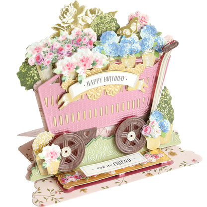 3D birthday card made with the 3D Wagon Easel Die Set, showcasing a pink garden wagon filled with vibrant flowers and displaying a "Happy Birthday" banner. The base reads "For My Friend.