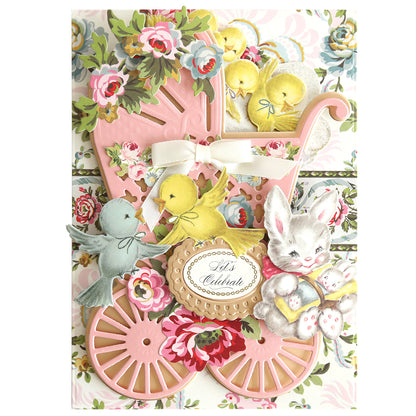 This vintage-style card features a pink baby carriage, floral patterns, colorful birds, and a bunny. Using Bunnies and Chicks Embellishment Stickers, "Let's Celebrate" comes to life in the center—perfect for springtime crafts.