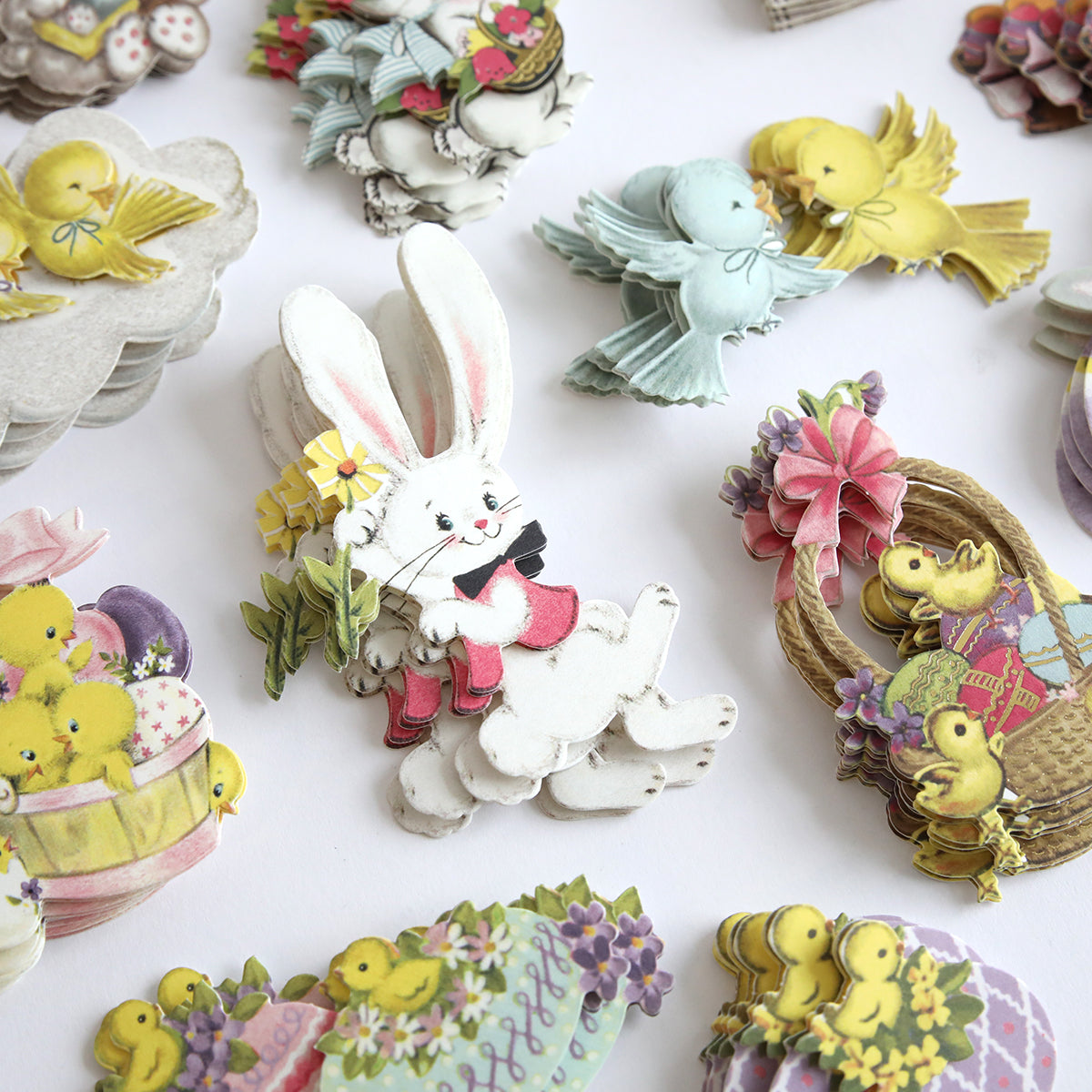 The Bunnies and Chicks Embellishment Stickers showcase vintage-style Easter die-cuts with rabbits, ducks, birds, floral designs, and egg motifs on a light background, ideal for enhancing your springtime crafts.