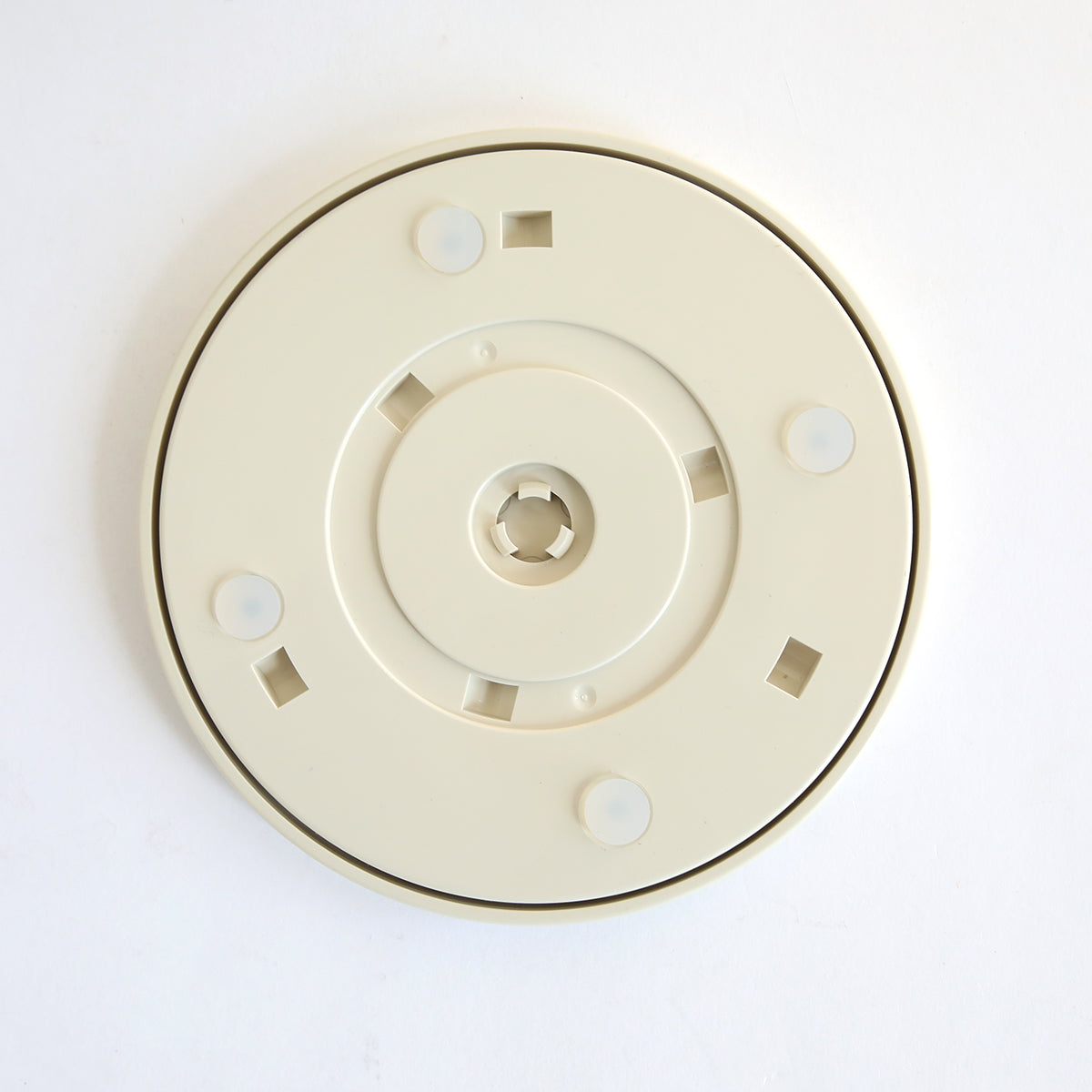 A beige, round plastic accessory disk with a central hole, square cutouts, and grips for the Empress Elite Mini Machine with 13" Plates. Shown on a white background.